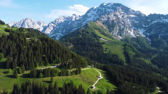 Aerial Drone Shot of Snow Peak Alps Mountain, Green Valley, and Pine Trees - Bavaria, Germany