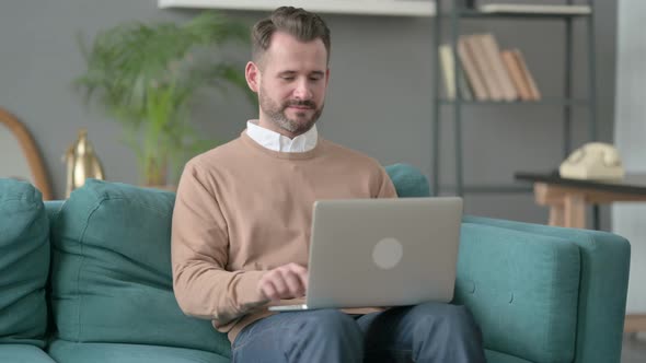 Man Working on Laptop on Sofa