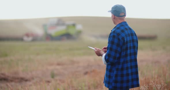 Farmer Using Digital Tablet While Examining Field