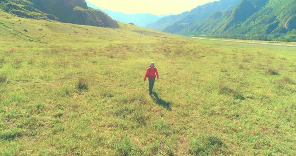 Flight Over Backpack Hiking Tourist Walking Across Green Mountain Field