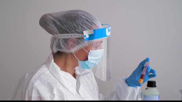 Doctor wearing protective clothing, doing blood test