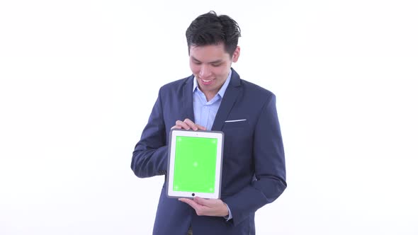 Happy Young Asian Businessman Thinking While Showing Digital Tablet