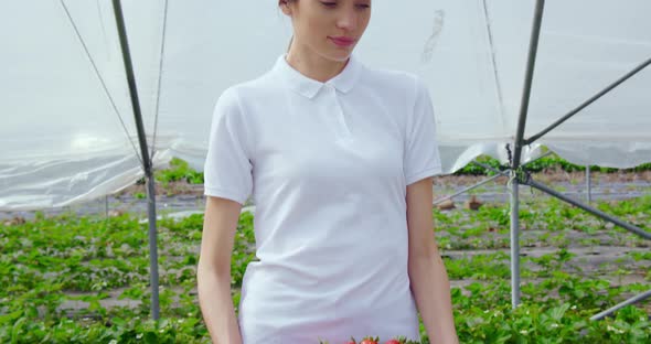 Happy Woman Holding Basket with Freshly Picked Strawberries