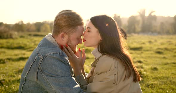 Loving Couple Hugging and Kissing on Meadow