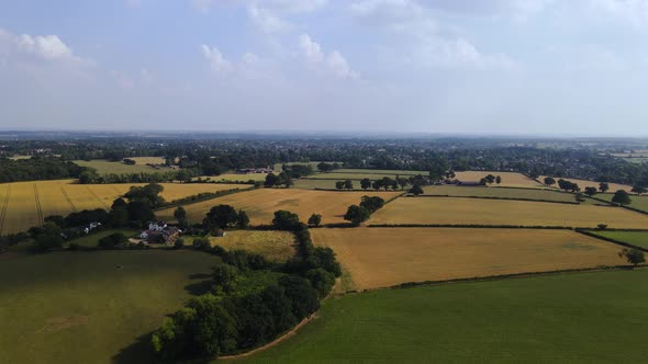 Countryside in Warwickshire, England with green and yellow fields on a sunny day. Ariel view. 4K