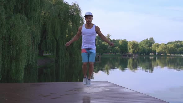 Muscular Young Man Jumping with Skipping Rope Near Lake