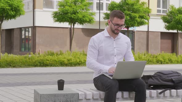 Young Freelancer Working on Laptop Outdoors