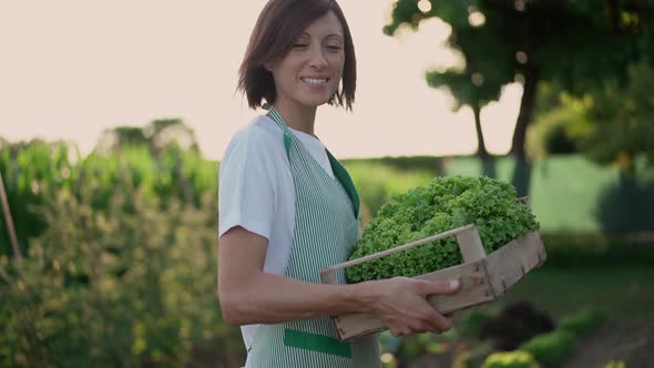 Smiling woman looking at camera standing in a vegetable garden