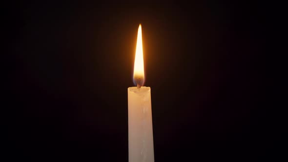 Closeup of an Isolated Burning Candle on a Black Background