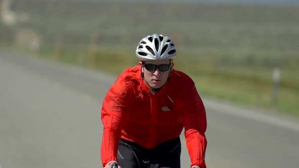 A man road biking on a scenic road.