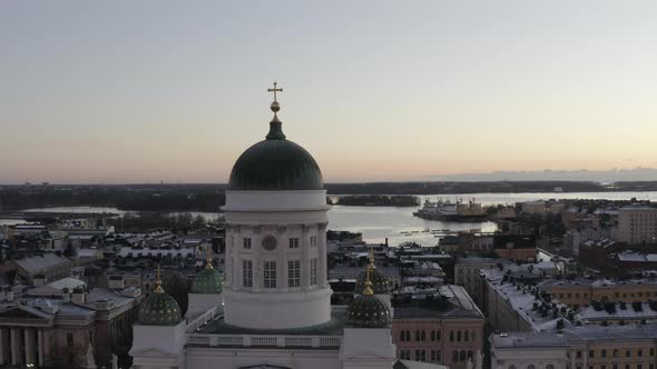 Aerial view drone flying close to the dome of Helsinki Cathedral with city and sea in background.