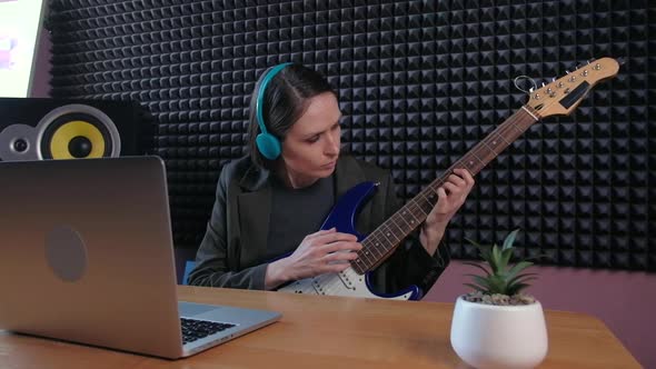 Female Learning Play Guitar at Home Using Online Lessons