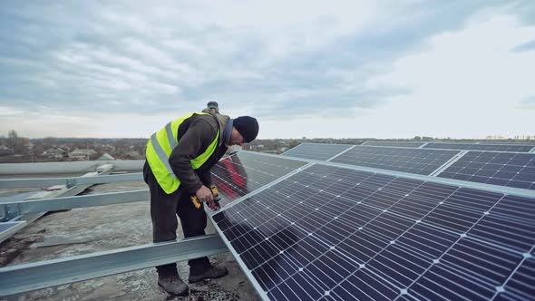 Technician with drill strengthens solar panel