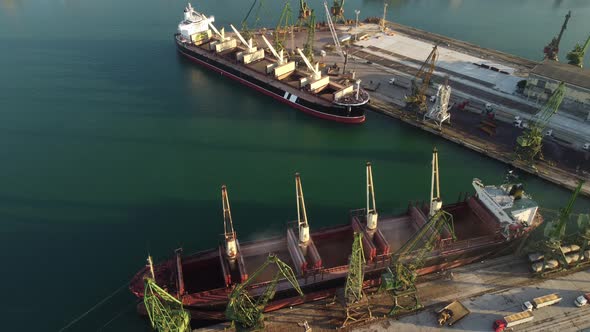 Aerial View of Big Cargo Ship Bulk Carrier is Loaded with Grain of Wheat in Port at Sunset