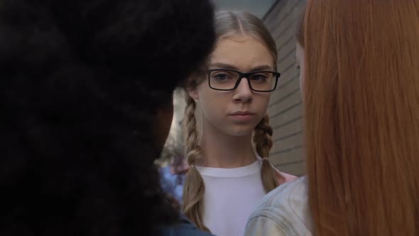 Female Students Stopping Girl in Schoolyard, Demonstrating Authority, Bullying