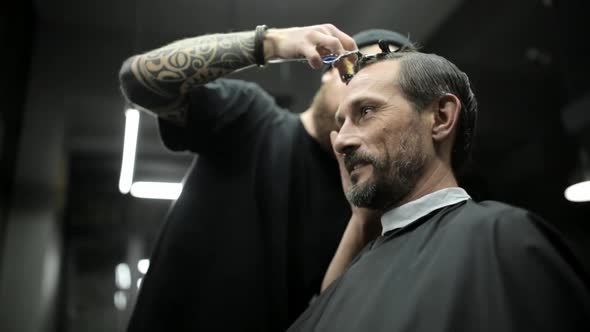 Haircut of Dark Haired Bearded Man in Barbershop