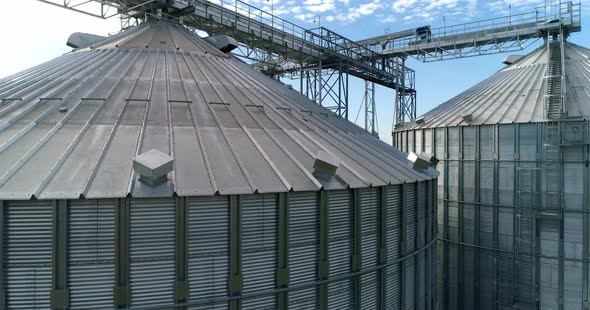 Large silver granary. Modern grain elevators. Metal industrial silos for agribusiness.