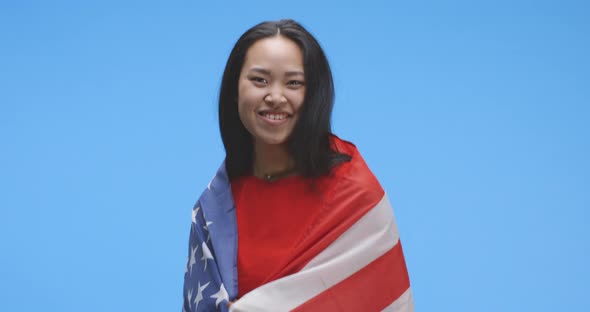 Young Woman Wrapped in and Dancing with Us Flag