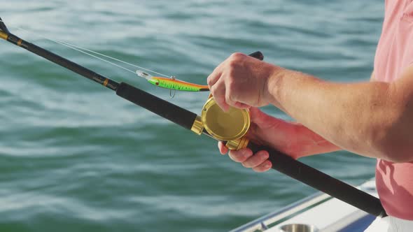 Side view mid section of a Caucasian man fishing on a boat