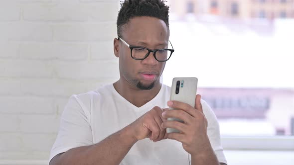 Portrait of Relaxed Casual African Man Using Smartphone