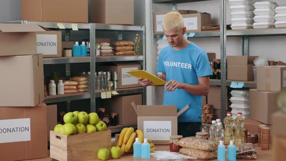 Man Clipboard Doing Inventory at Warehouse of Food Bank