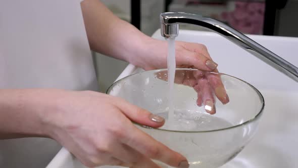 Woman Doctor Beautician in Robe Pours Water Into a Large Bowl To Wash the Face