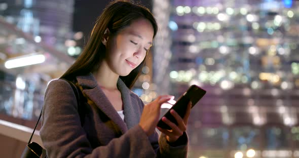 Business woman use of mobile phone in city at night