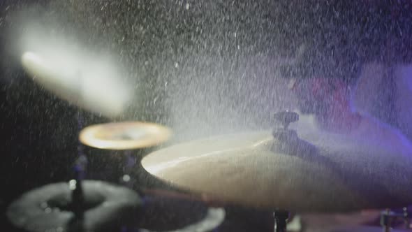 The Drummer Hits the Wet Drum Cymbal with His Drumstick and the Water Splashes in Slow Motion