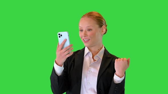 Young Woman Making a Video Call with Her Smartphone on a Green Screen Chroma Key