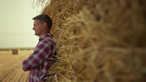 Man Rest Hay Stack at Agricultural Field