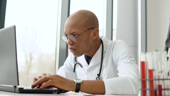 Young African American Male Doctor Working at Desk