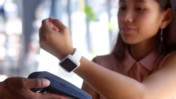 Teenage girl making payment through smartwatch 4k