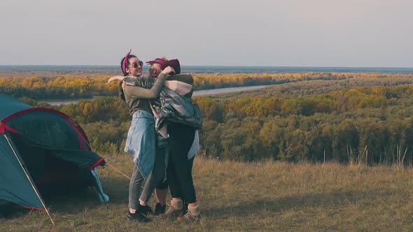 Plump Young Woman Hugs Friends with Laughter in Campsite