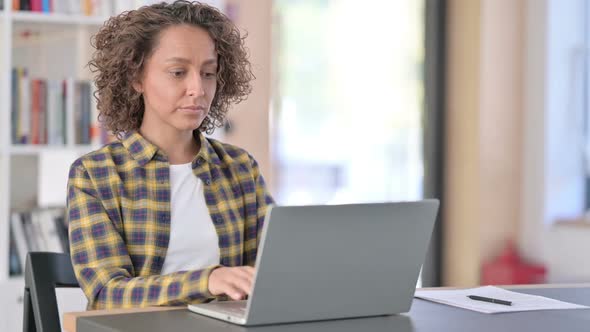 Young Mixed Race Woman Closing Laptop Leaving