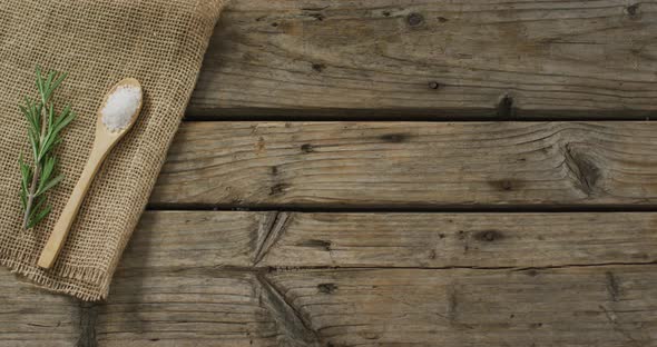 Video of rosemary twig and spoon of salt on wooden background