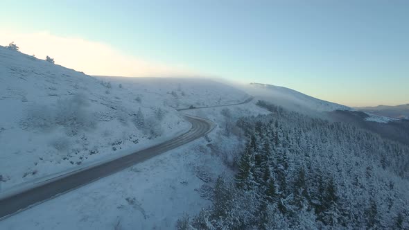 Trucks Driving Slowly on Mountain Highway with Majestic View in Bulgaria in Snowy Day