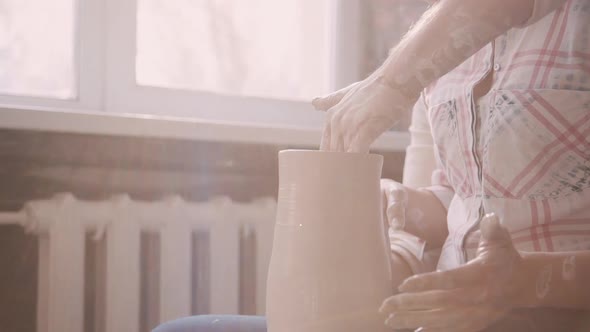 Two Concentrated Potter Masters Working with Raw and Wet Clay in