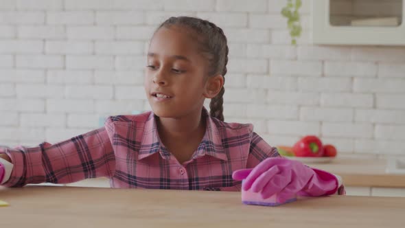 Industrious African Girl Polishing Kitchen Table alt