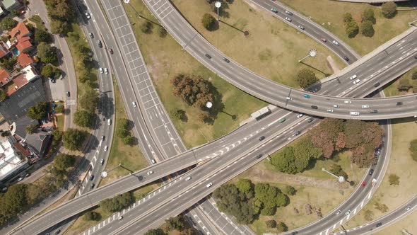 Aerial top down shot rising over traffic driving on a highway interchange. Wide view