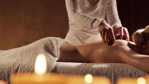 Young, healthy and beautiful woman gets massage therapy in the spa salon.