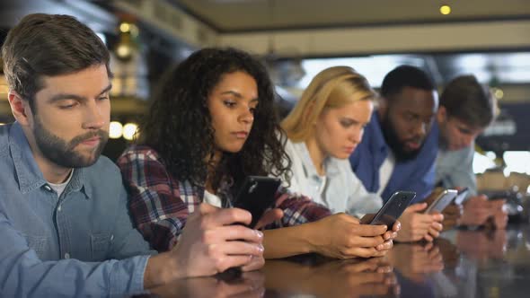Multi-Racial Friends Scrolling Smartphones Ignoring Each Other, Gadget Addiction