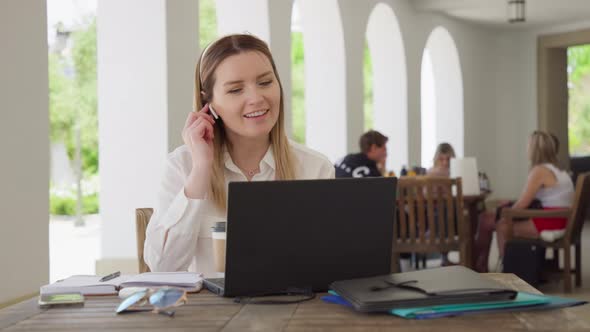 Young Caucasian Business Woman with Headphones Communicating Video By Call