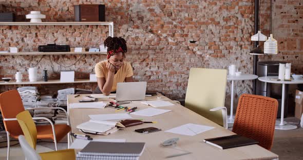 Slow motion shot of design student using laptop sitting at table