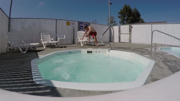 Young Man is Lying Down on a Sunbed at a Hotel Relaxing Jacuzzi on Foreground