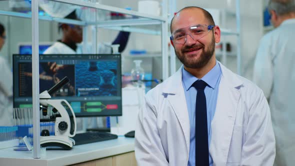 Microbiologist Sitting in Laboratory Looking at Camera