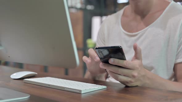 Close Up Shoot of Guy Hands Using Smartphone and Keyboard