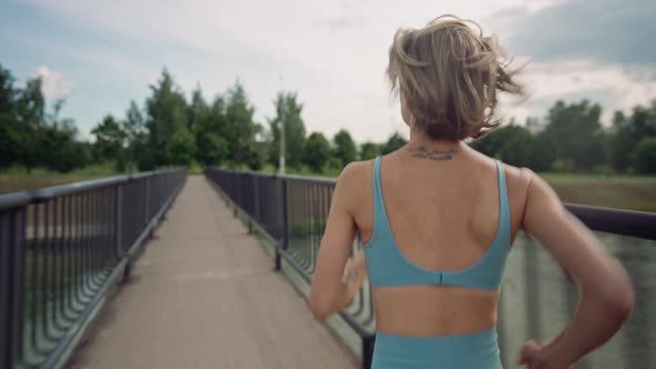 Woman Running in the Middle of the Bridge