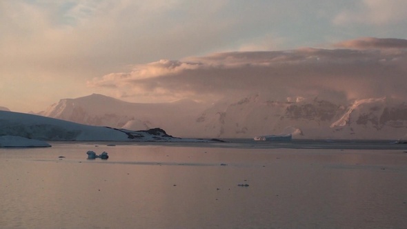 Sunset in Antarctica, with calm sea water.