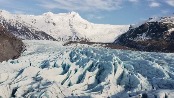 Drone Towards Large Glacier With Snow Covered Mountains