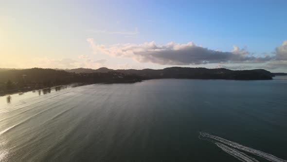 Flying drone past 2 jet skis on New Zealand North Island beach at sunset